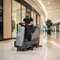 Home Professional cleaner operating a ride-on floor scrubber in a UAE mall